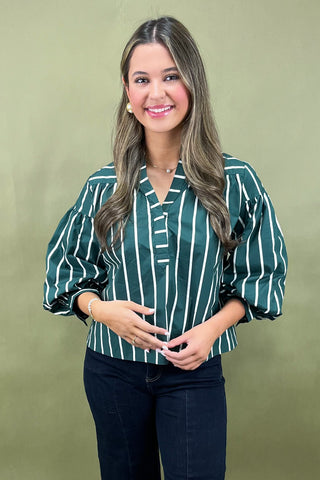 Woman wearing a green and white striped shirt against a green background