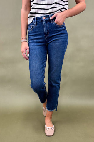 Person wearing blue jeans and a striped top on a plain background