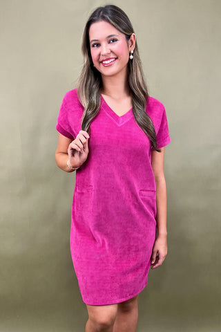 Woman wearing a pink dress against a beige background