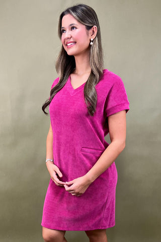 Woman wearing a pink dress against a plain background