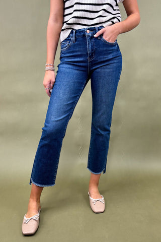 Person wearing blue jeans and a striped top on a green background