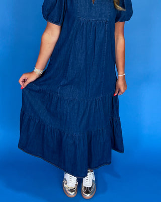 Person wearing a blue dress against a blue background