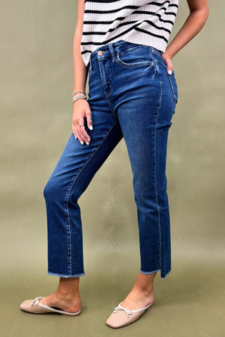 Person wearing blue jeans and a striped top on a plain background
