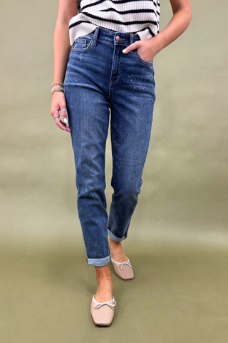 Person wearing blue jeans and a striped top on a green background