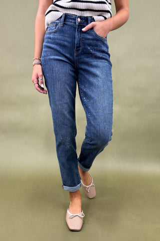 Person wearing blue jeans and a striped top on a green background