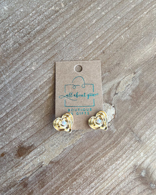 Shop the Holly Pearl Heart Earrings featuring layered gold hearts with a faux pearl center for a timeless, romantic boutique look.