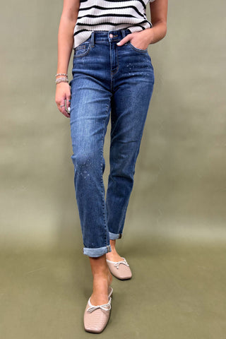 Person wearing blue jeans and a striped shirt on a plain background