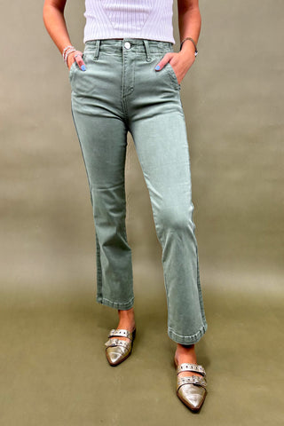 "Women’s sage green straight-leg pants with side pockets, styled with a white ribbed top and metallic pointed-toe flats – casual chic outfit."
