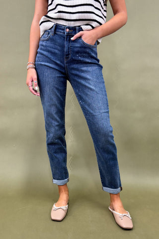 Person wearing blue jeans and a striped top on a plain background