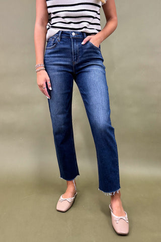Person wearing blue jeans and a striped top on a plain background