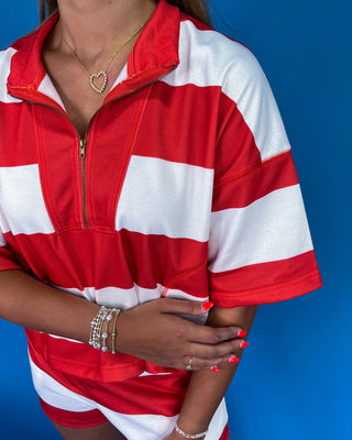 Woman wearing a red and white striped outfit against a blue background