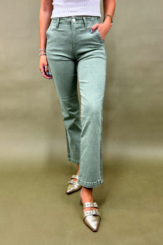 Women’s sage green straight-leg pants with side pockets, styled with a white ribbed top and metallic pointed-toe flats – casual chic outfit.