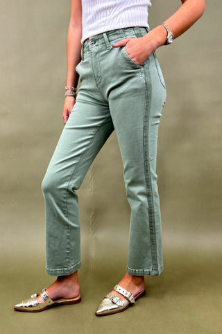 Women’s sage green straight-leg pants with side pockets, styled with a white ribbed top and metallic pointed-toe flats – casual chic outfit.