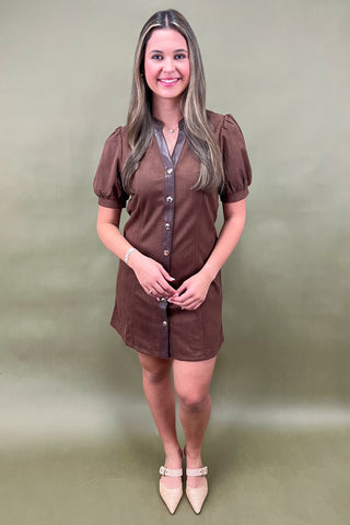 Woman wearing a brown dress with a plain background