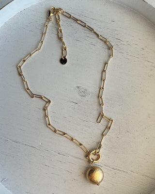Shop the Gold Charm Necklace featuring a paperclip chain, textured gold charm, adjustable fit, and timeless style perfect for layering or everyday wear.