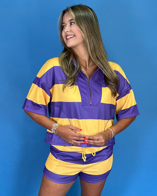 Woman wearing a purple and yellow striped outfit against a blue background