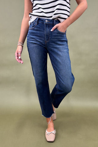 Person wearing blue jeans and a striped top on a green background