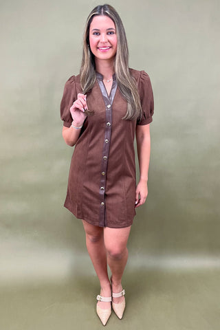 Woman wearing a brown dress with a plain background