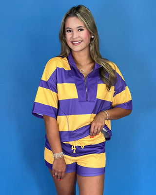 Woman wearing a purple and yellow striped outfit against a blue background