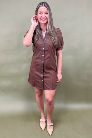 Woman wearing a brown dress with a plain background