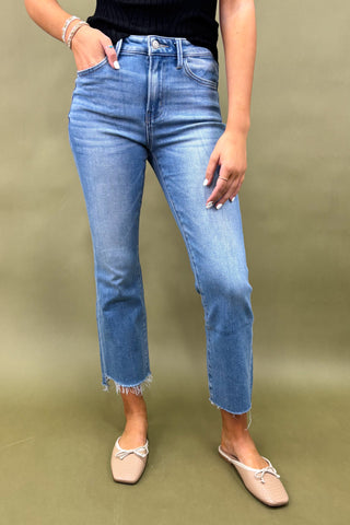 Person wearing blue jeans on a green background