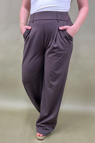 Person wearing brown wide-leg pants on a plain background