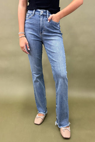 Person wearing blue jeans on a plain background