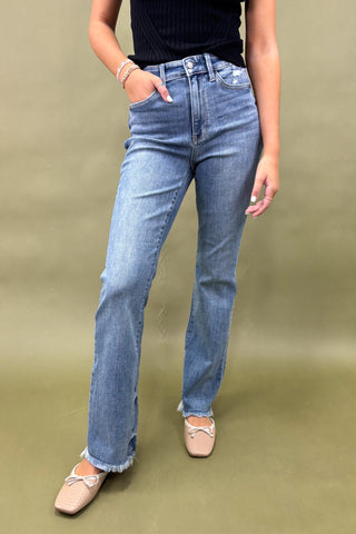 Person wearing blue jeans on a green background