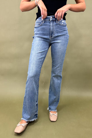 Person wearing light blue jeans on a plain background