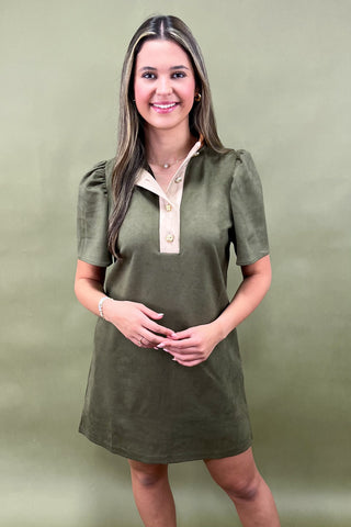 Woman wearing a green dress with a white collar against a green background