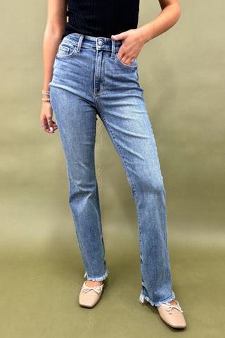 Person wearing light blue jeans on a green background
