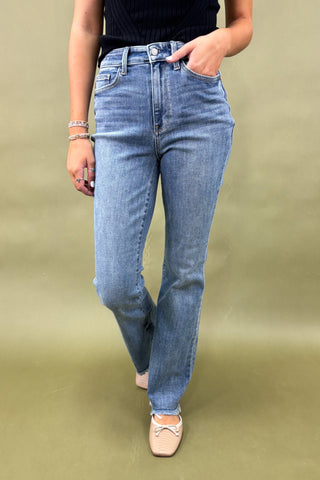 Person wearing blue jeans on a plain background