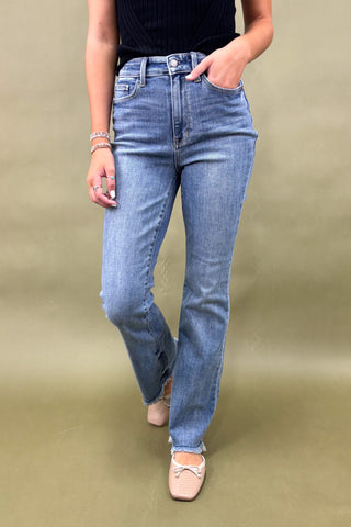 Person wearing blue jeans on a beige background
