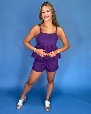 Woman wearing a purple outfit against a blue background