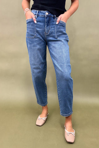 Person wearing blue jeans on a plain background