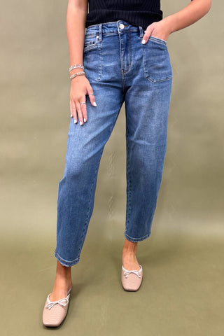 Person wearing blue jeans on a plain background