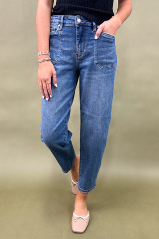 Person wearing blue jeans on a plain background