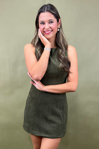 Woman wearing an olive green dress against a matching background