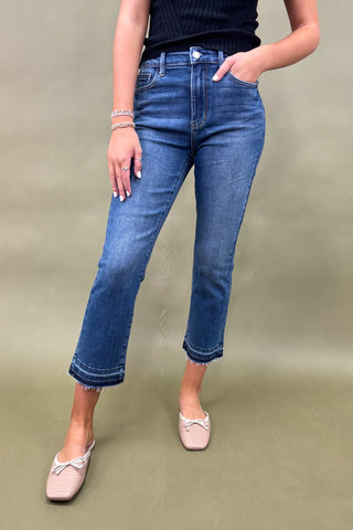 Person wearing blue jeans on a plain background