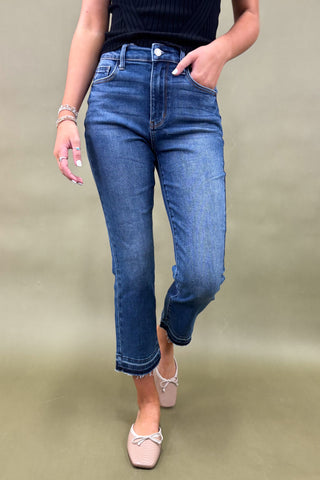 Person wearing blue jeans on a plain background
