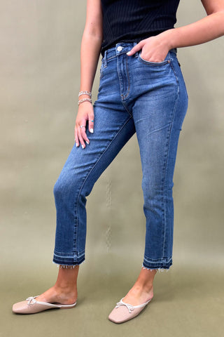 Person wearing blue jeans on a plain background