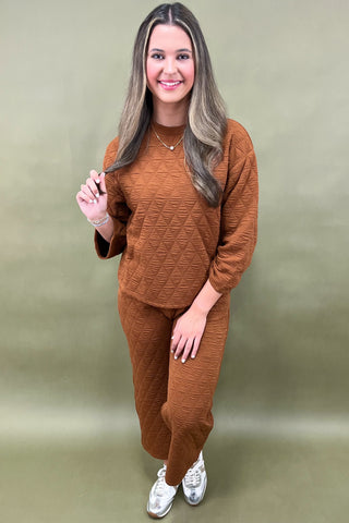 Woman wearing a brown outfit against a green background