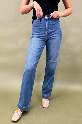 Person wearing blue jeans on a plain background