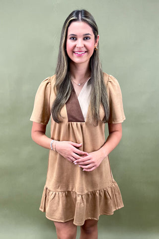 Woman wearing a beige dress against a green background