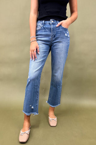 Person wearing blue jeans on a green background