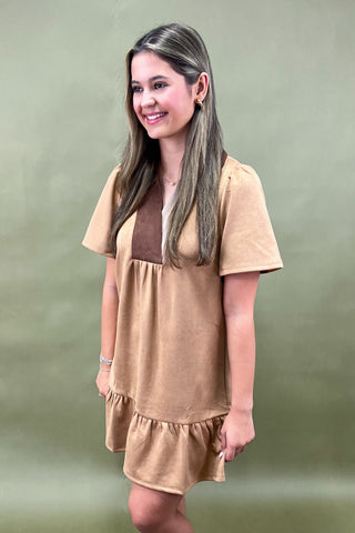 Woman wearing a beige dress against a green background