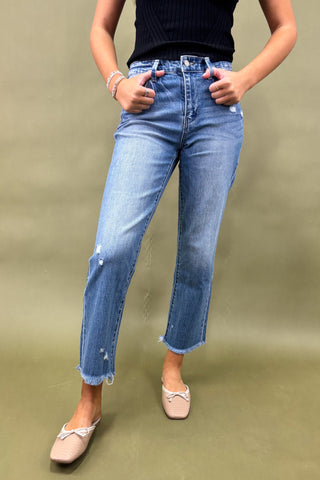 Person wearing blue jeans on a plain background