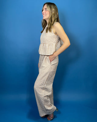 Tan and white gingham sleeveless peplum top with high neckline and matching wide leg pants set.