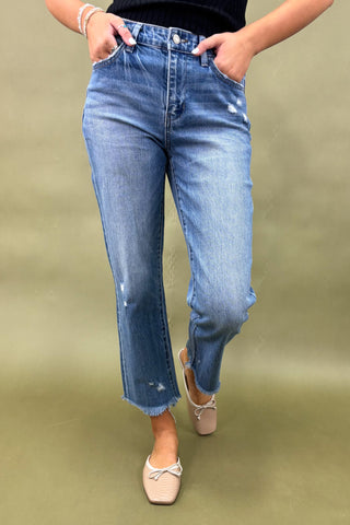 Person wearing blue jeans on a green background