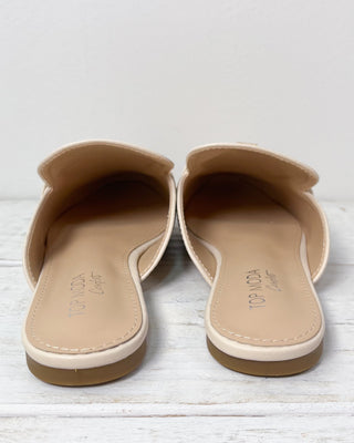 Pair of beige sandals on a light wooden surface